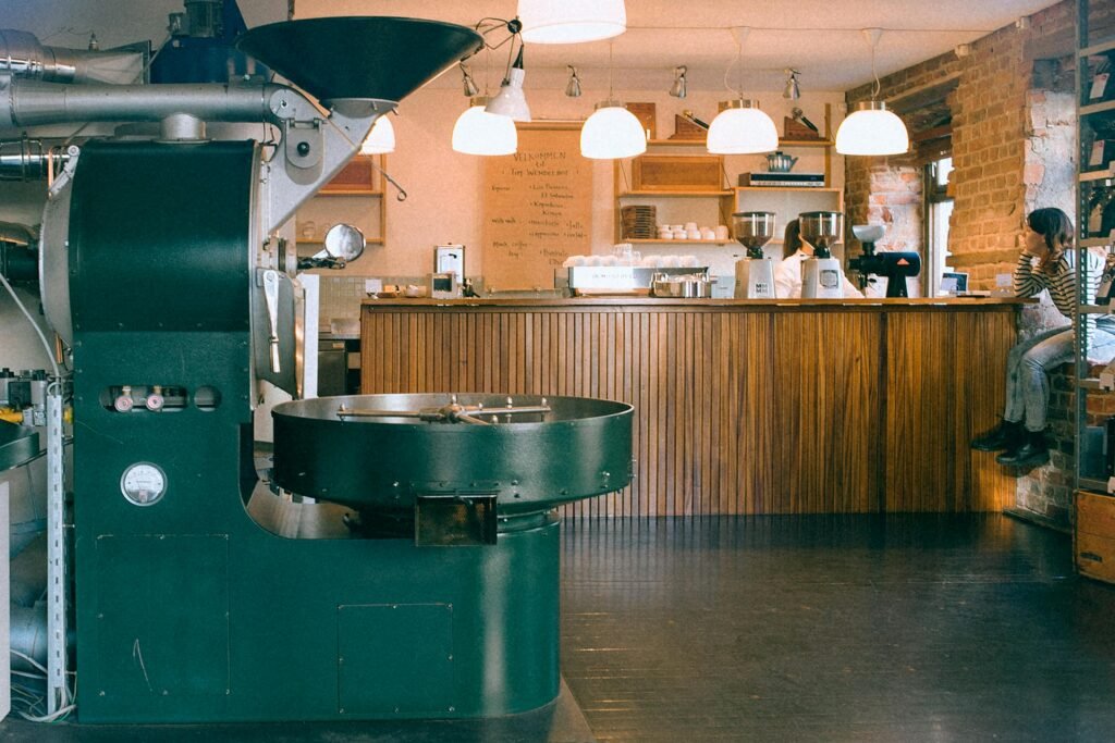 Warm and inviting café interior with coffee roasting machine and bar seating.