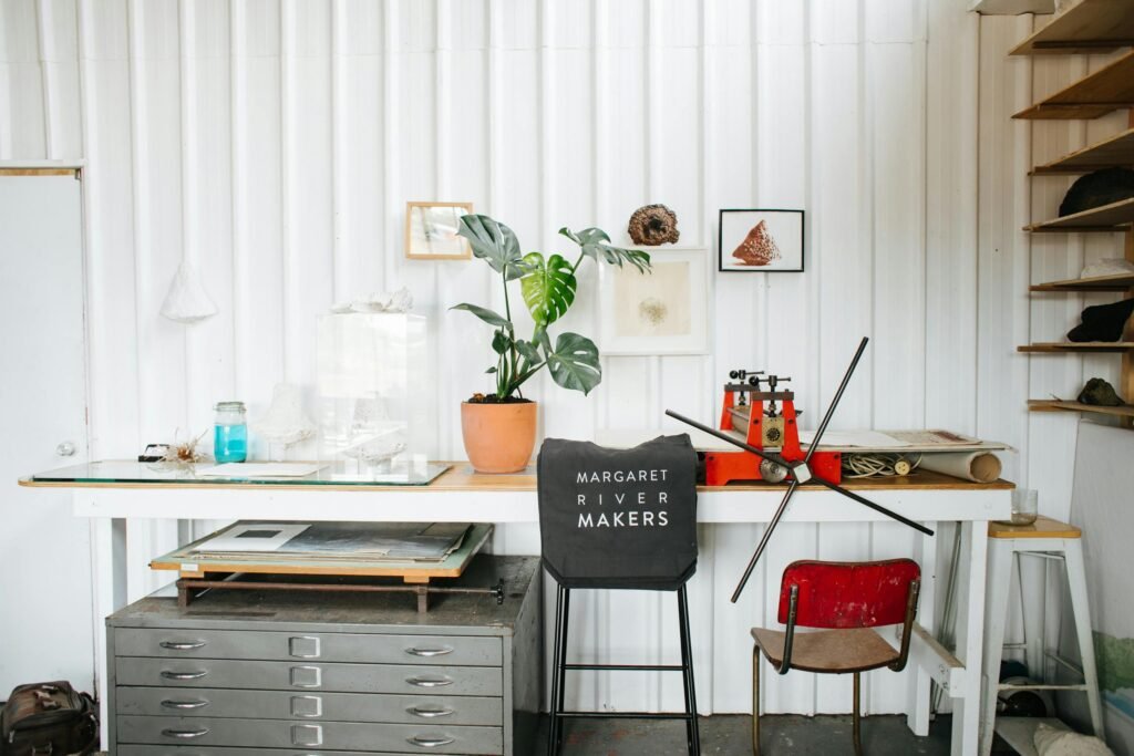 Artistic studio featuring a vintage printing press, decor elements and plants.