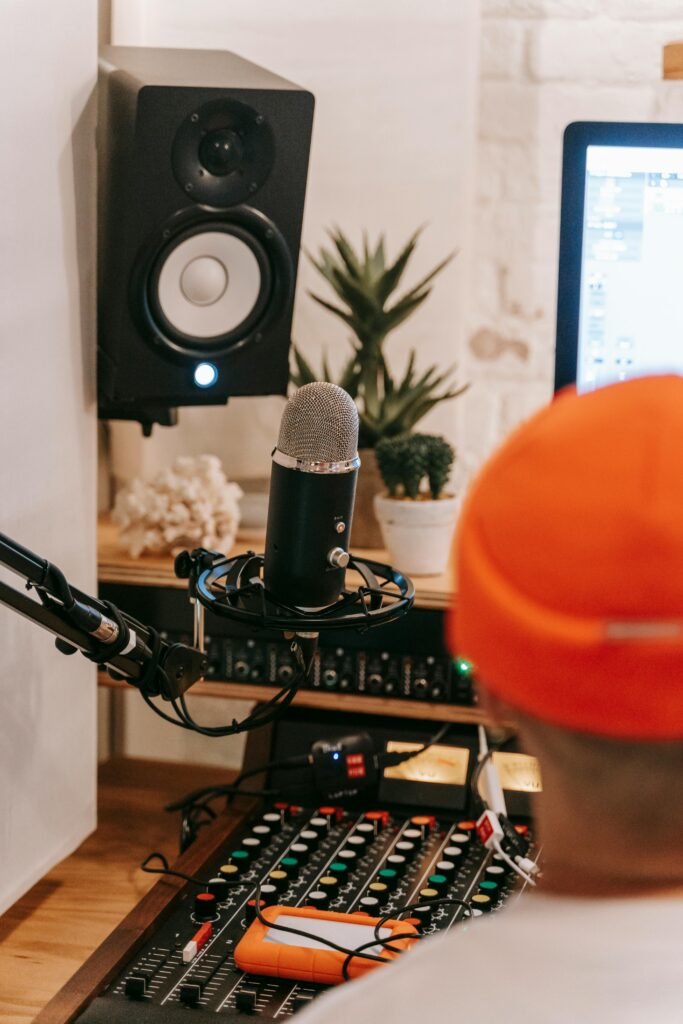 A well-equipped recording studio featuring a condenser microphone, mixer, and speakers.